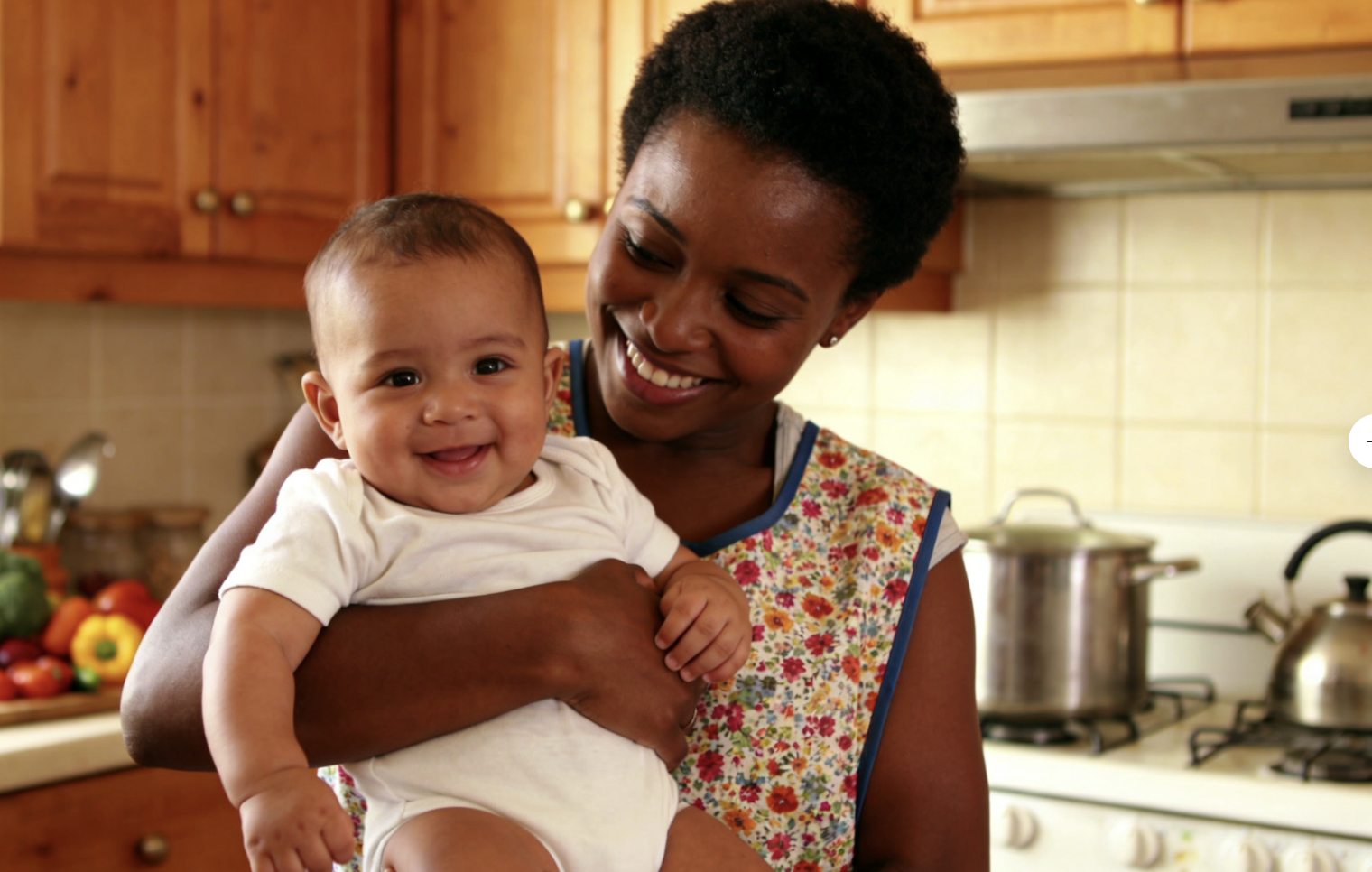 African mother with baby in kitchen